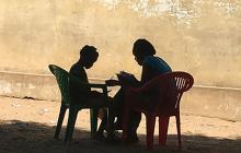 Adult and child reading in silhouette in Mozambique