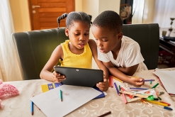 Image of young boy and girl looking at a tablet together